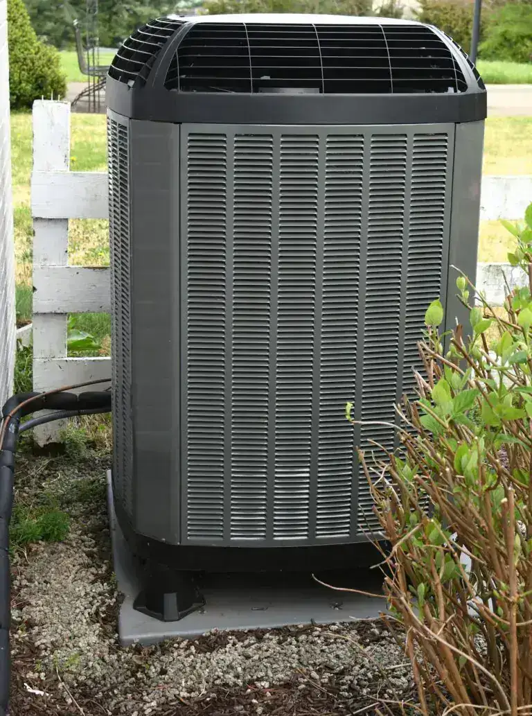 Air source heat pump beside a home